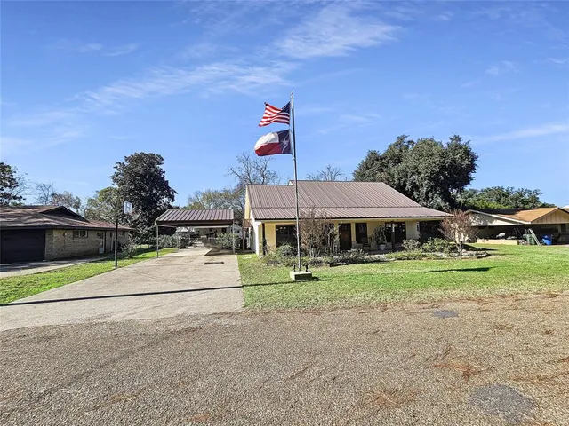 a front view of a house with a yard and trees