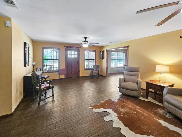 a living room with furniture and a wooden floor