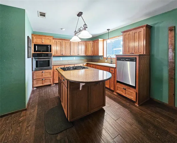 a kitchen with stainless steel appliances granite countertop a stove a sink and a refrigerator