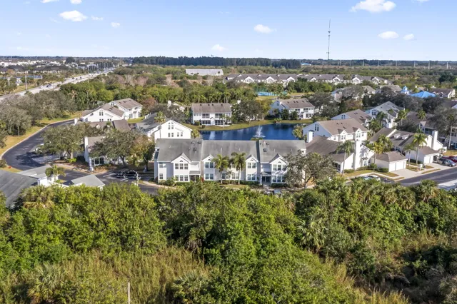 an aerial view of a city with lots of residential buildings ocean and mountain view in back