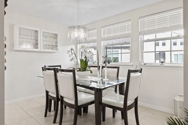 a view of a dining room with furniture a chandelier and a window