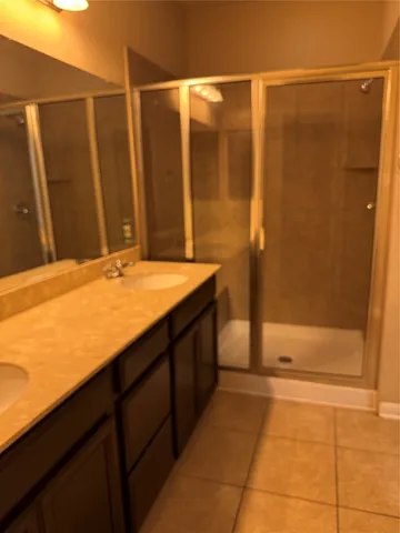 a bathroom with a double vanity sink and shower
