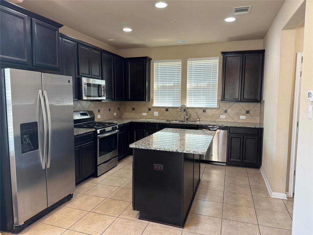 7220 Wyoming Springs Drive, Unit 1301 Round Rock, TX 78681 - Photo 6 of 21 a kitchen with stainless steel appliances granite countertop a sink stove and refrigerator