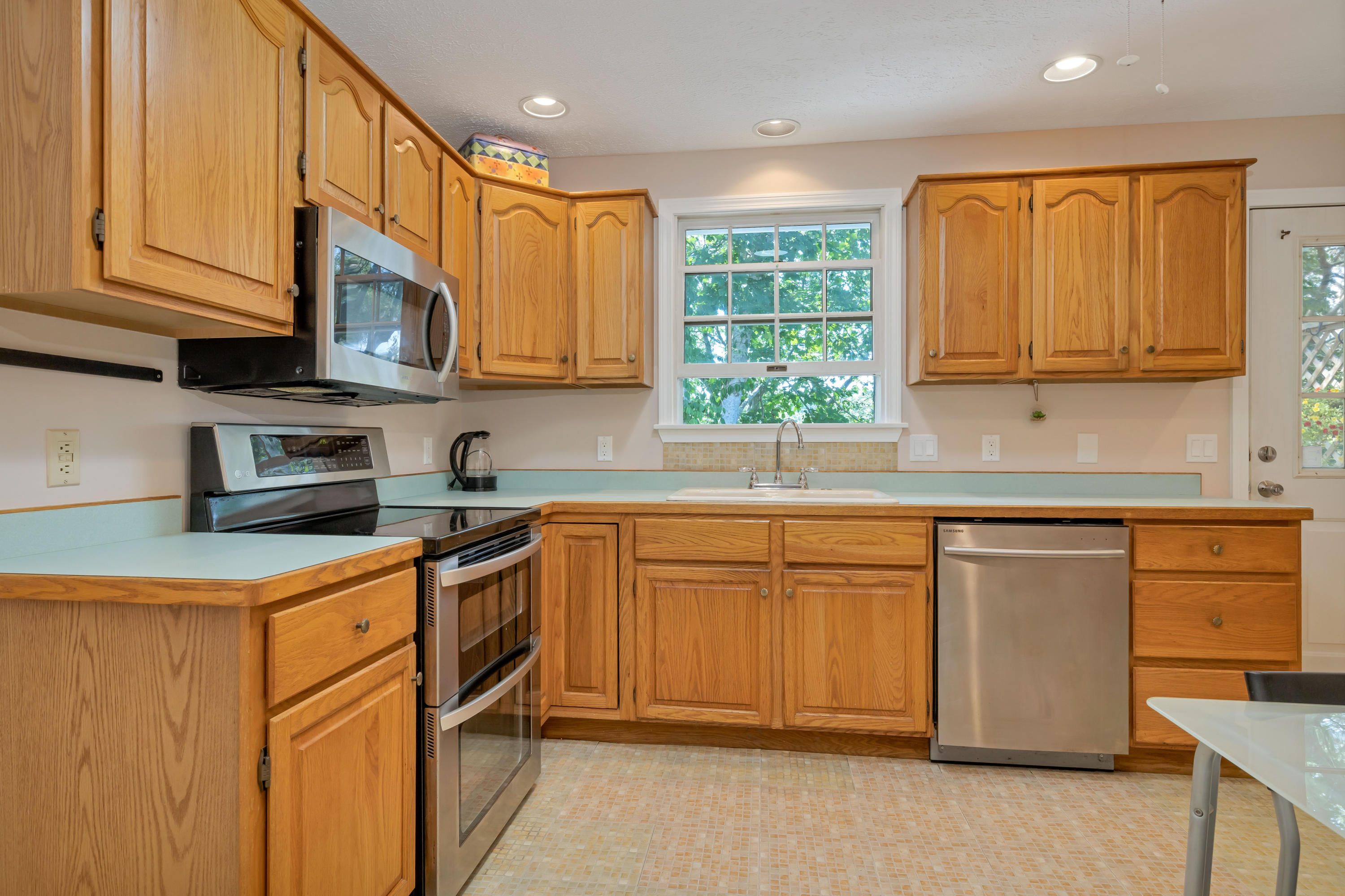 9 Green Pond Road East Falmouth, MA 02536 - Photo 10 of 46 a kitchen with stainless steel appliances granite countertop a stove a sink dishwasher and a refrigerator with wooden cabinets