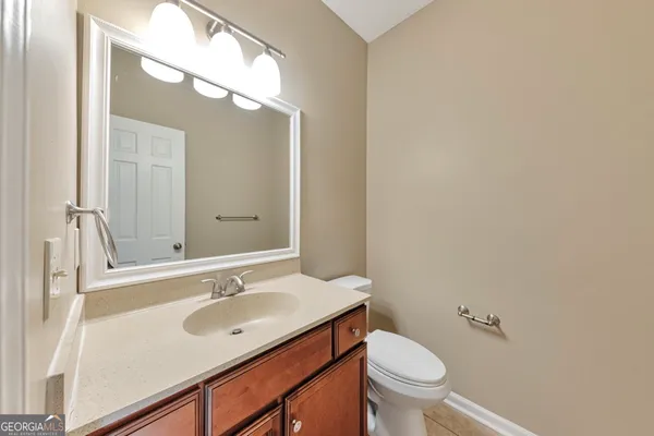 a bathroom with a sink a toilet and a mirror
