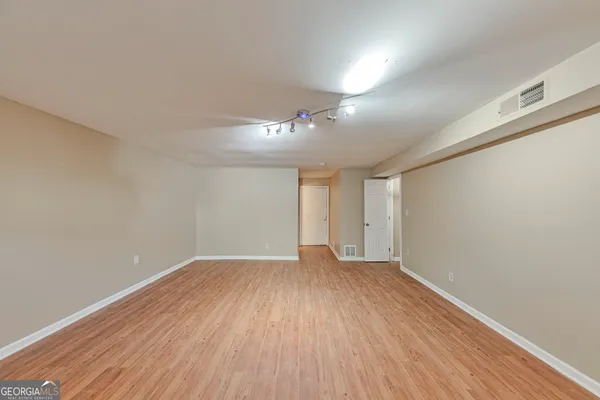 a view of an empty room with wooden floor