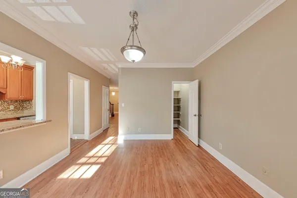 a view of hallway with window and wooden floor