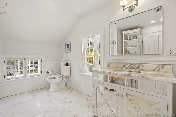 a bathroom with a sink a toilet and a window