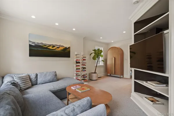 a living room with furniture a flat screen tv and gym equipment