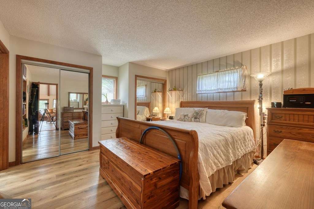 241 Kilpatrick Point Drive, Unit 8 Hayesville, NC 28904 - Photo 24 of 54 a bedroom with a bed and wooden floor