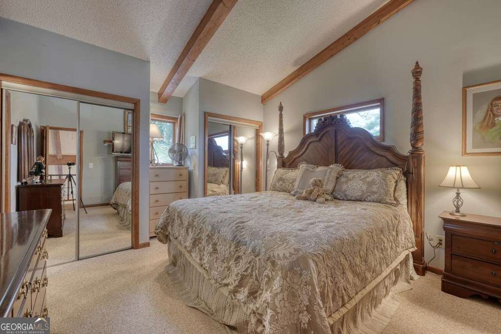 241 Kilpatrick Point Drive, Unit 8 Hayesville, NC 28904 - Photo 31 of 54 a spacious bedroom with a bed and a mirror