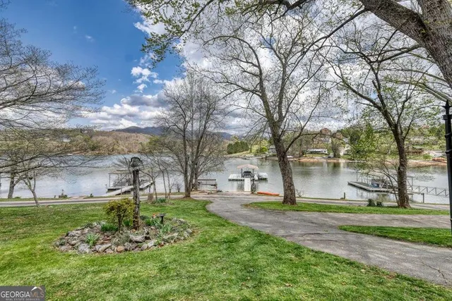 a view of house with lake swimming pool and outdoor seating