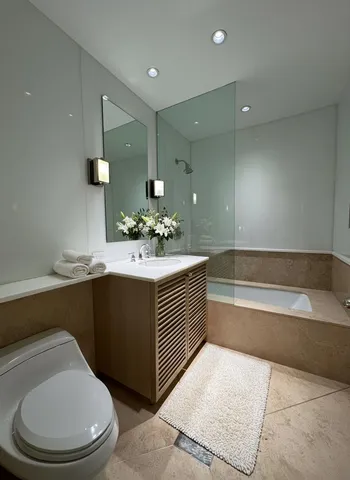 a bathroom with a sink a toilet and mirror