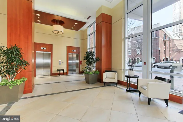 a lobby with furniture and potted plants