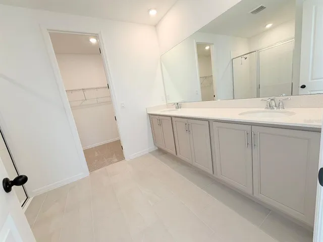 a bathroom with a double vanity sink and a mirror
