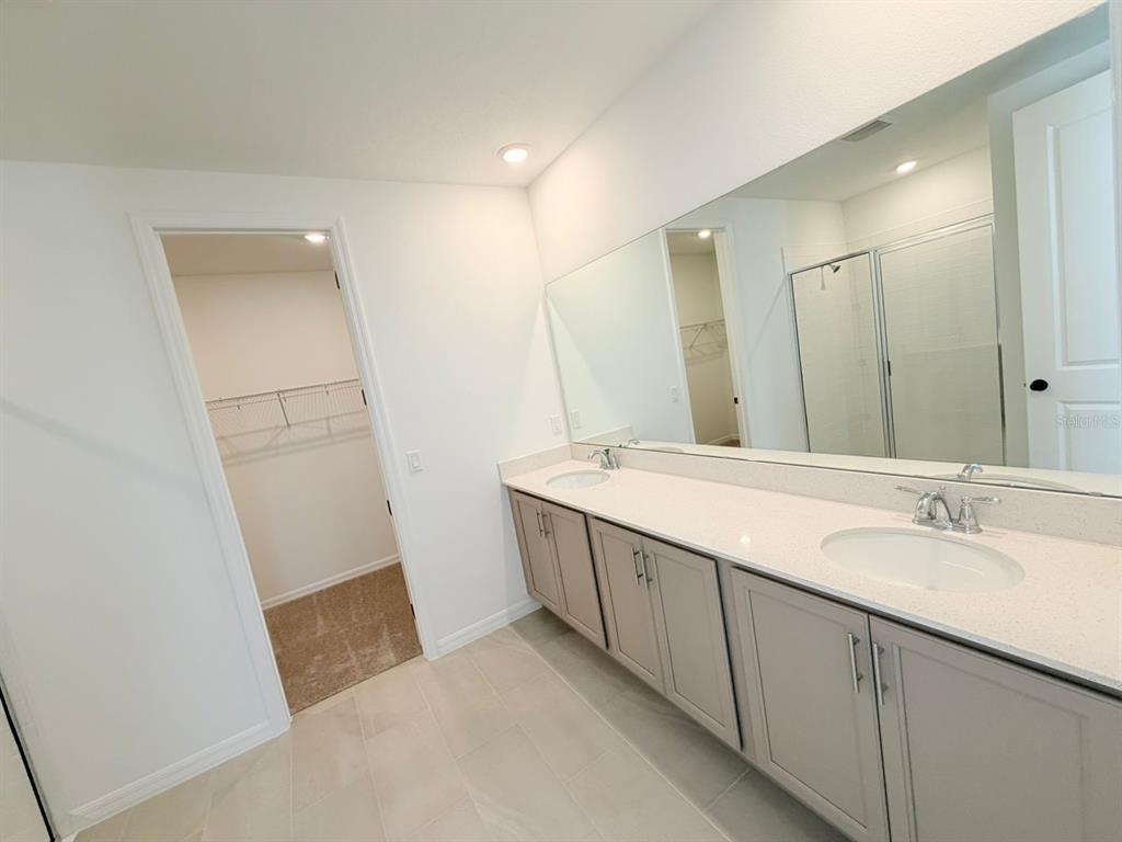 30155 Rustic Mill St Mount Mount Dora, FL 32757 - Photo 16 of 20 a bathroom with a double vanity sink and a mirror