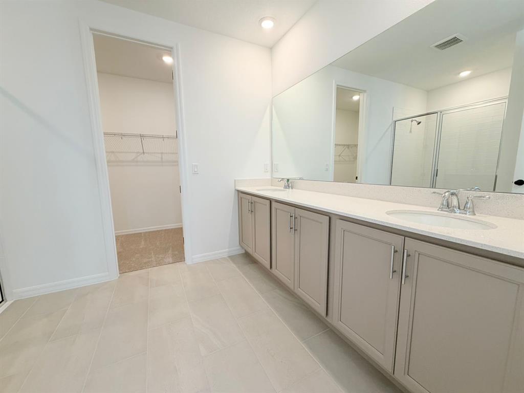30155 Rustic Mill St Mount Mount Dora, FL 32757 - Photo 19 of 20 a spacious bathroom with a double vanity sink a mirror and a shower