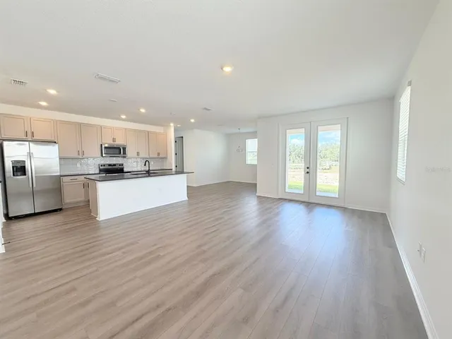a view of kitchen with wooden floor and electronic appliances