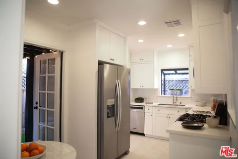 a kitchen with stainless steel appliances white cabinets and white appliances