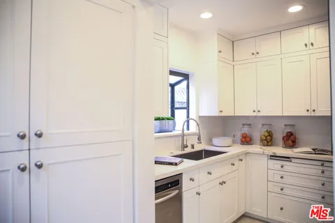 a kitchen with granite countertop white cabinets and stainless steel appliances