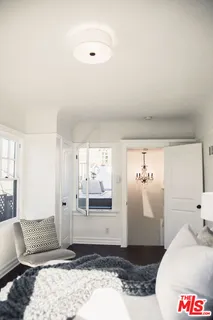 a view of a bedroom with wooden floor and a cabinet