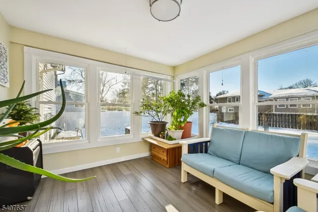 a living room with furniture a potted plant and a large window