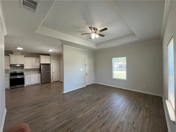 a view of a big room with wooden floor and a kitchen