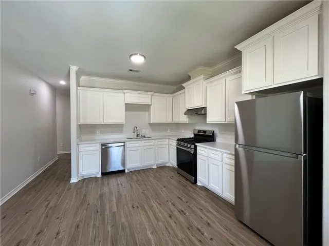 a kitchen with a refrigerator stove and wooden cabinets