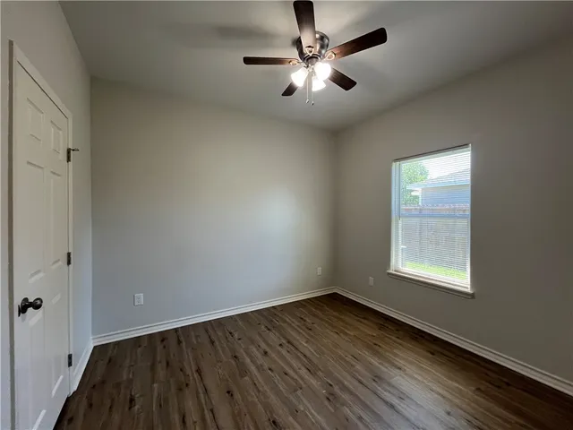 an empty room with a window and a fan
