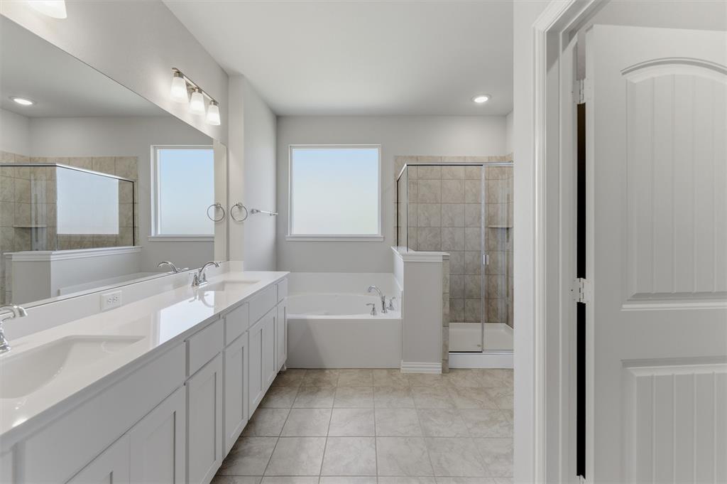 1225 Sabine River Lane Springtown, TX 76082 - Photo 17 of 25 Full bath with double vanity, a stall shower, a garden tub, and light tile patterned flooring