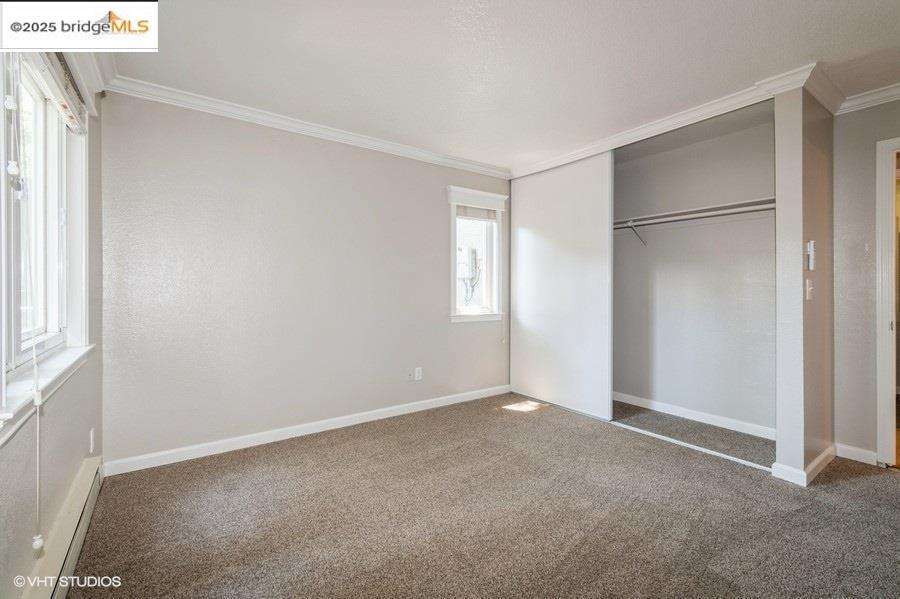 1505 Kirker Pass Road, Unit 170 Concord, CA 94521 - Photo 13 of 18 Unfurnished bedroom featuring ornamental molding, carpet, a closet, and a baseboard heating unit