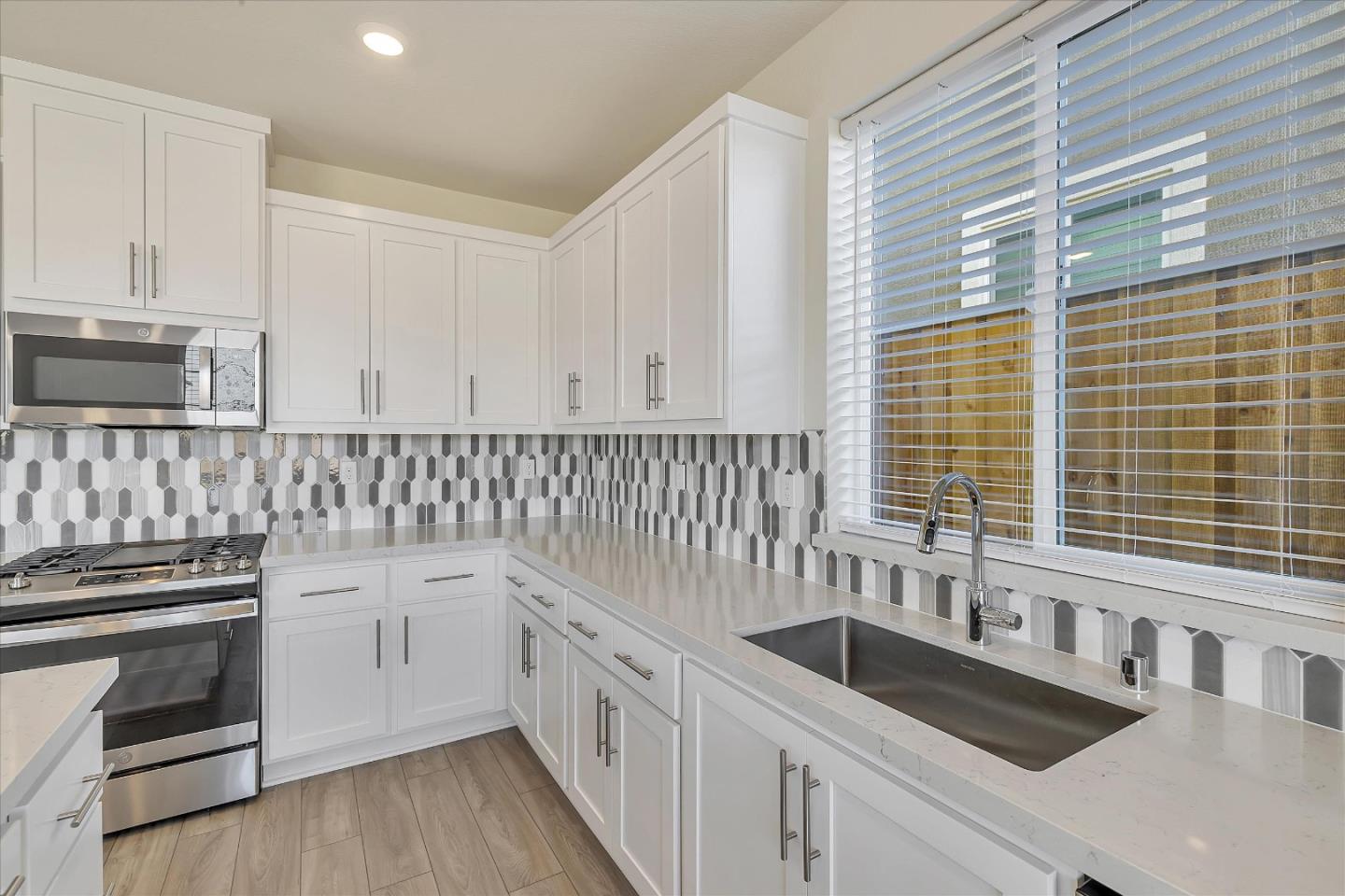 5459 Posner Avenue Tracy, CA 95377 - Photo 7 of 29 a kitchen with granite countertop a sink and a stove