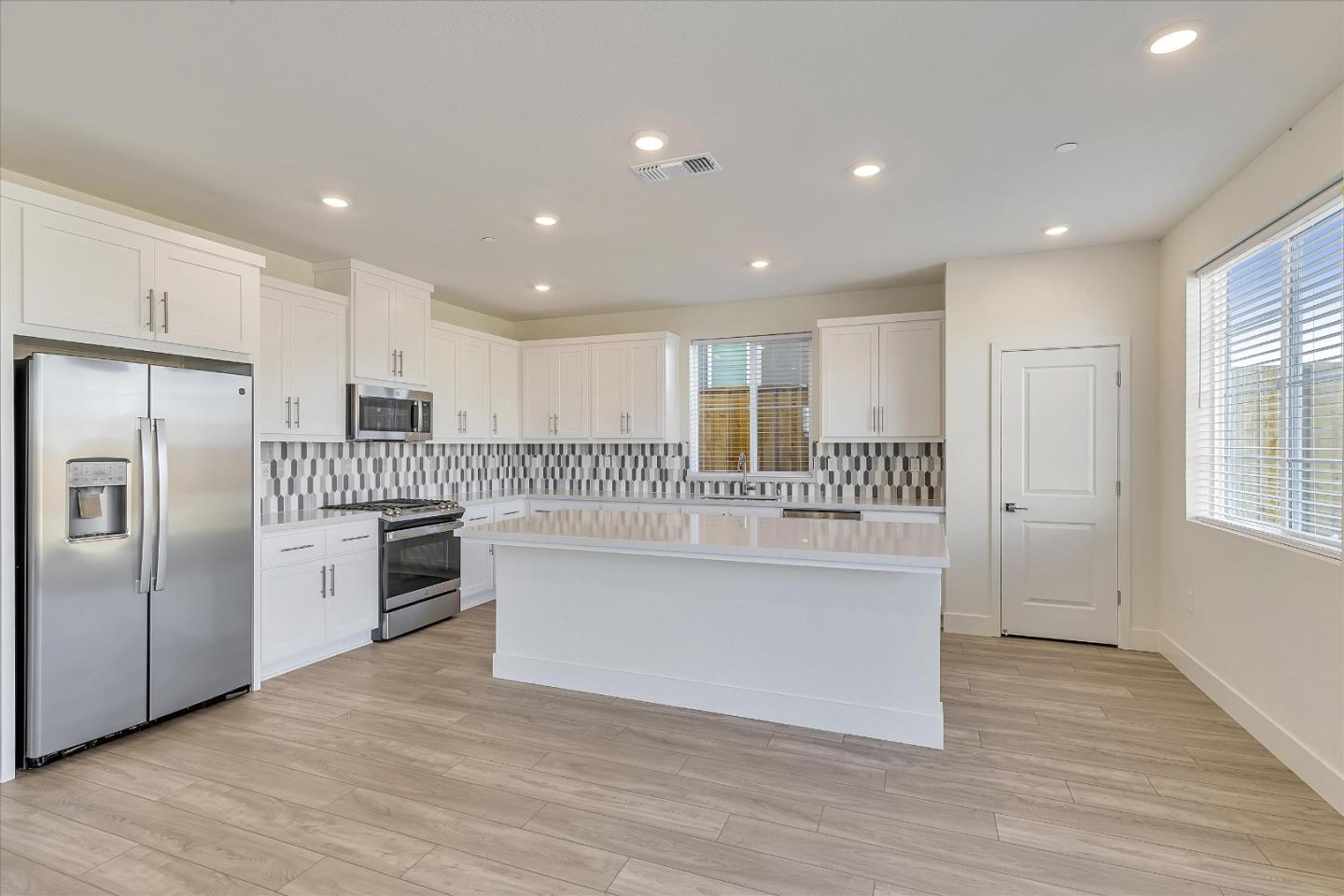 5459 Posner Avenue Tracy, CA 95377 - Photo 8 of 29 a large kitchen with a center island wooden floor and stainless steel appliances