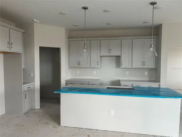 a kitchen with kitchen island a sink stainless steel appliances and cabinets