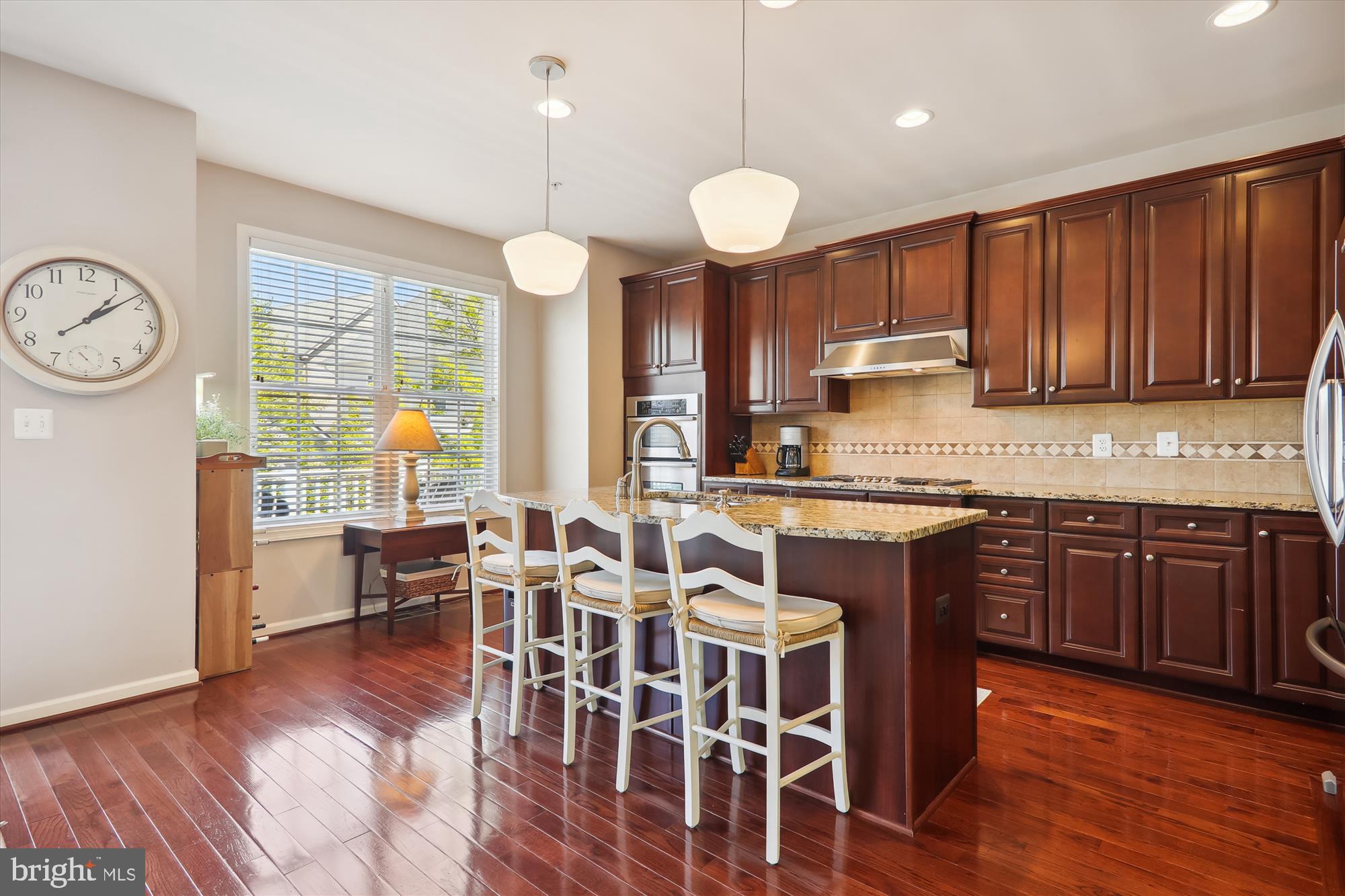 1609 Poplar Run Drive Silver Spring, MD 20906 - Photo 24 of 71 a kitchen with stainless steel appliances granite countertop wooden floors stove a dining table and chairs