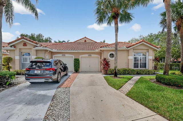 front view of a house with a yard and potted plants