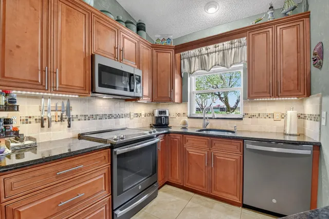 a kitchen with stainless steel appliances granite countertop a refrigerator and a stove top oven