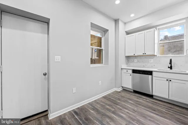 a kitchen with a sink window and cabinets