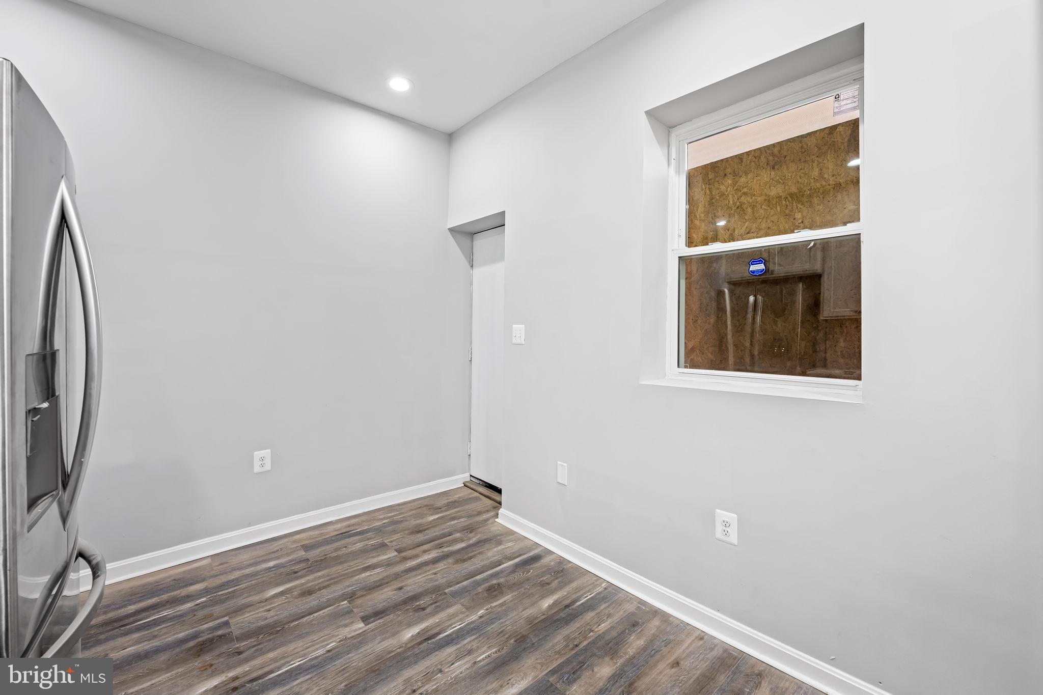 1918 East Lafayette Avenue Baltimore, MD 21213 - Photo 13 of 30 a view of an empty room with wooden floor and a window