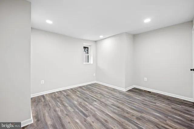 a view of room with wooden floor and white walls
