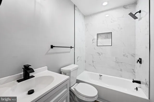 a bathroom with a sink a toilet and bathtub