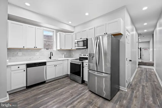 a kitchen with a refrigerator stove and wooden cabinets