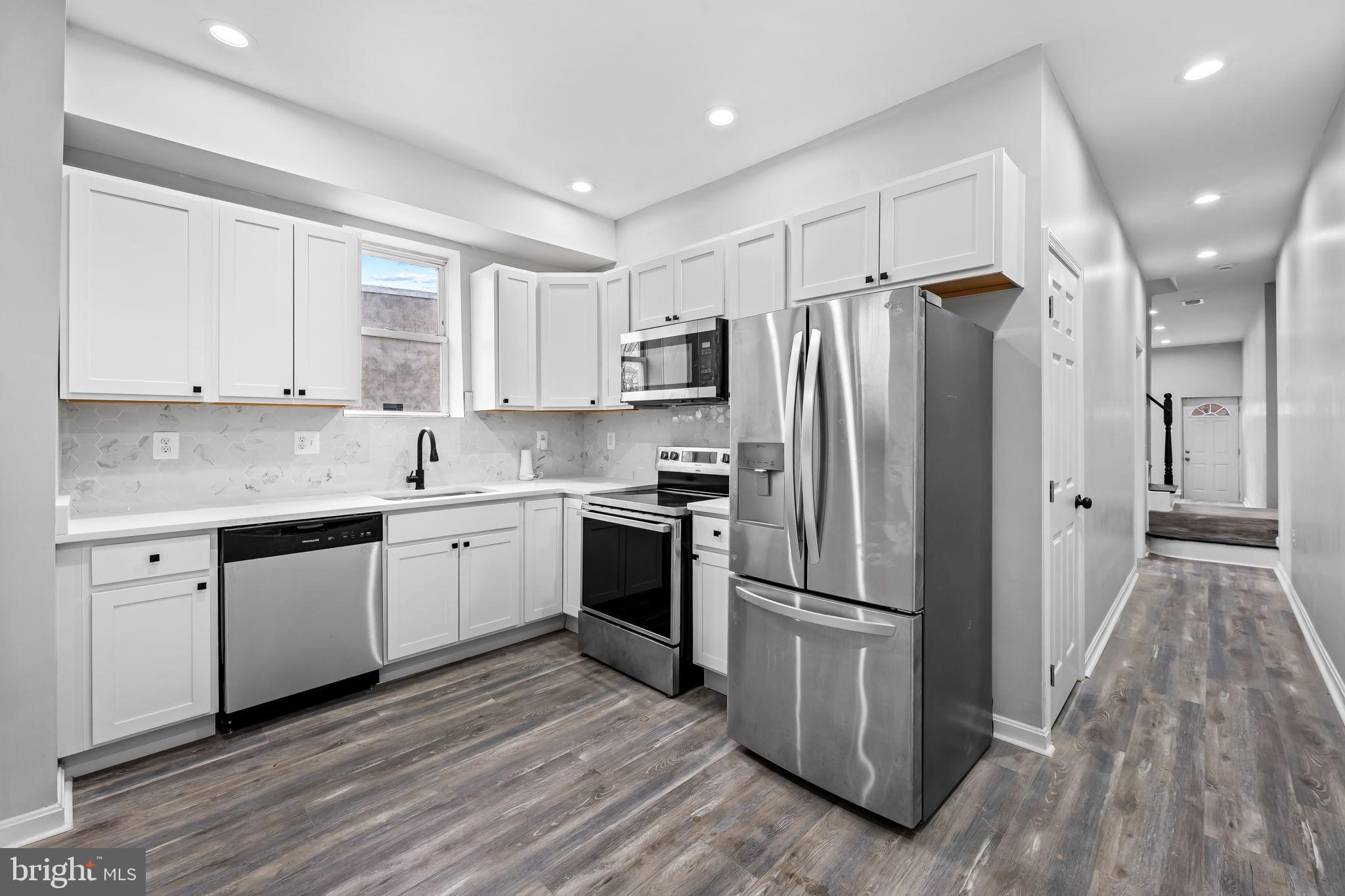1918 East Lafayette Avenue Baltimore, MD 21213 - Photo 9 of 30 a kitchen with a refrigerator stove and wooden cabinets
