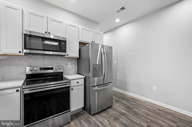 a kitchen with stainless steel appliances a stove a microwave and a refrigerator