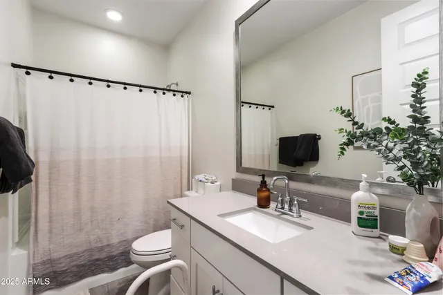 a bathroom with a granite countertop sink toilet a mirror and shower