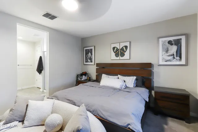 a bedroom with a bed and a painting on the wall