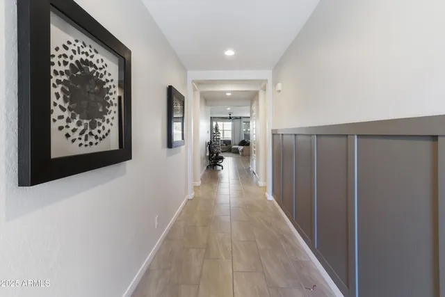 a view of a hallway with wooden floor and a living room
