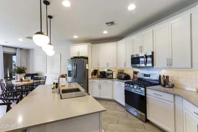 a kitchen with kitchen island white cabinets and stainless steel appliances