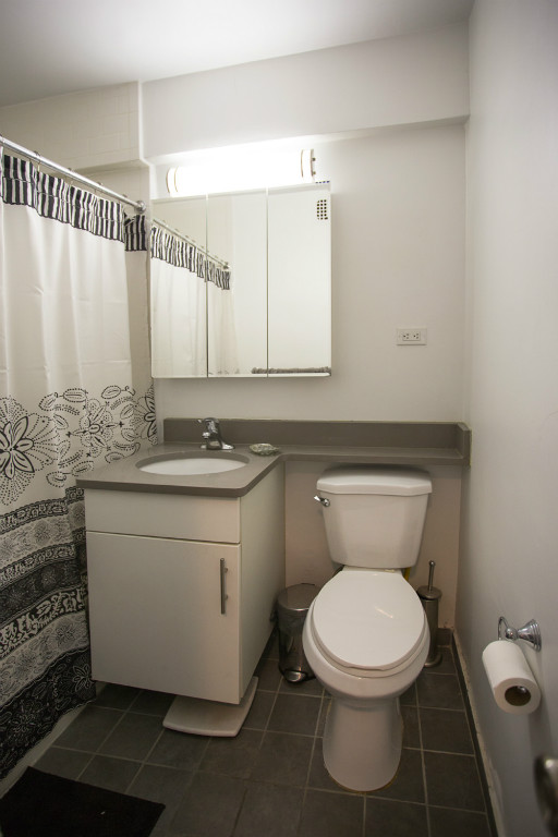 a bathroom with a granite countertop toilet and a sink
