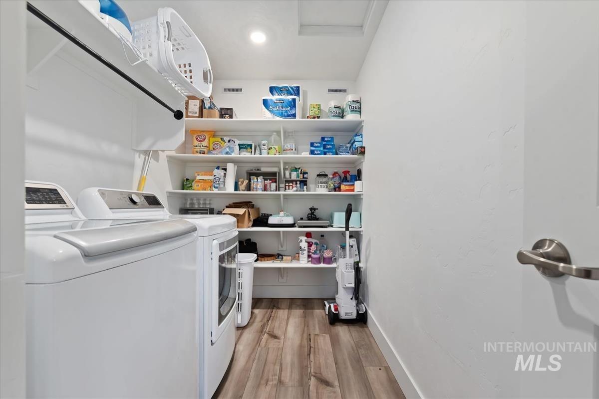 815 Knowledge Street Middleton, ID 83644 - Photo 38 of 49 Dedicated laundry area featuring wood-finish flooring, overhead clothes rod, recessed lighting, and extensive built-in shelving